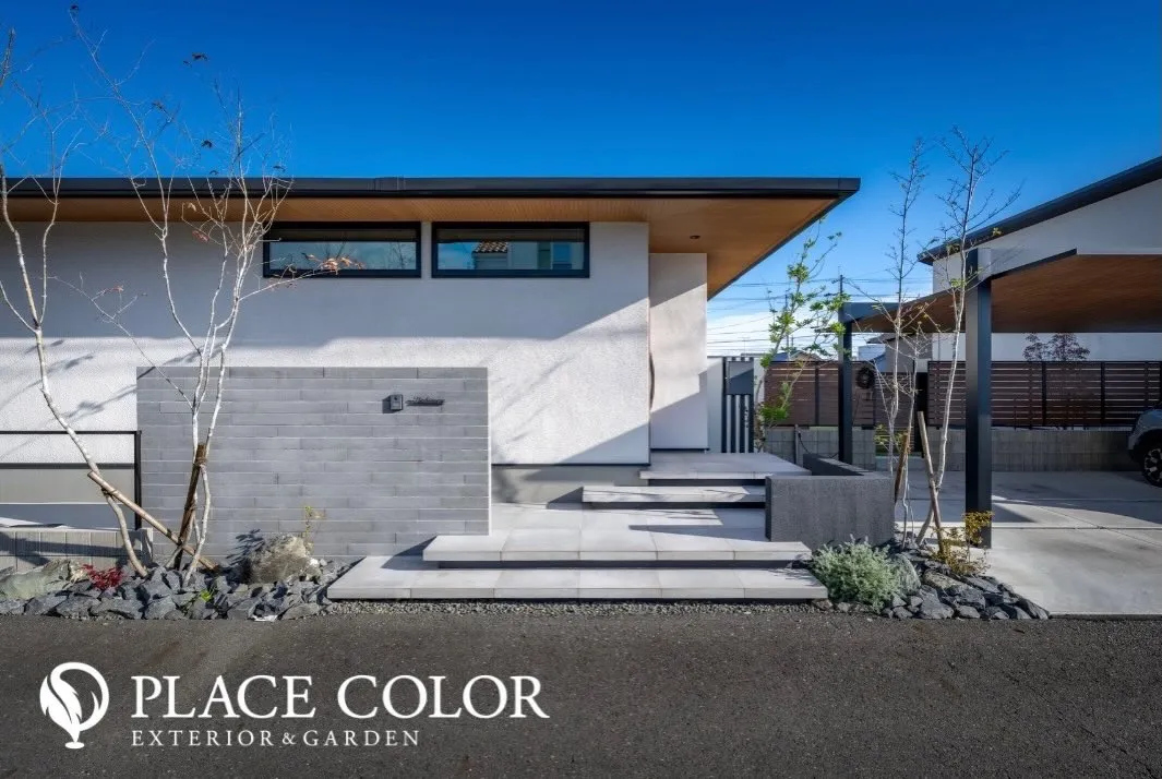 広がりのあるステップが軽やかな動線を生み、門まわりの低い壁が...